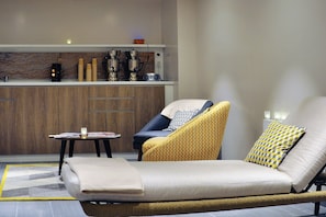 A modern living room with a sofa, armchair, and a small table with magazines. - Chalet in La Clusaz with Pool & Spa (La Clusaz)