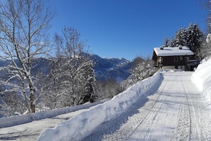 A snow-covered mountain road leading to a cabin with a clear sky. - Chalet in La Clusaz with Pool & Spa (La Clusaz)