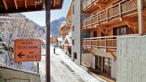 A snow-covered village with wooden buildings and a sign indicating access to telecabine WC facilities. - Chalet in Chatel by Super Chatel Gondola (Chatel)