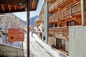 A snow-covered village with wooden buildings and a sign indicating access to telecabine WC facilities. - Chalet in Chatel by Super Chatel Gondola (Chatel)