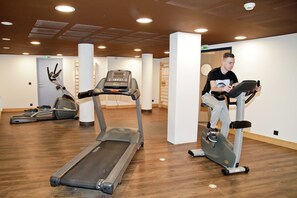 A gym with treadmills and elliptical machines, wooden flooring, and a modern ceiling design. - Chalet in Chatel by Super Chatel Gondola (Chatel)