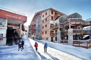 A snow-covered street with buildings, including a hotel with a sign reading 'Super-Chatel.' - Chalet in Chatel by Super Chatel Gondola (Chatel)