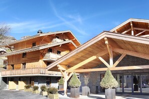 Ein Holzhaus mit Balkon und überdachter Eingangszone.