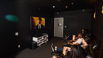 Enjoy a cinematic experience in this cozy movie theater with a flat-screen TV and comfortable black leather chairs.