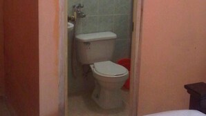 A small bathroom with a toilet, sink, and a towel hanging on the wall. - Residencial Rio Hato (Rio Hato)