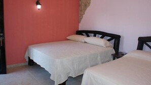 A room with two beds, a wall-mounted light, and a door. - Residencial Rio Hato (Rio Hato)