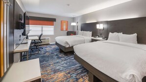 A hotel room with two beds, a desk, a chair, a TV, and a window with blinds. - Clarion Pointe Marshall (Marshall)