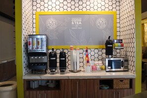 A coffee station with a coffee maker, decaf machine, and a microwave. - Clarion Pointe Marshall (Marshall)