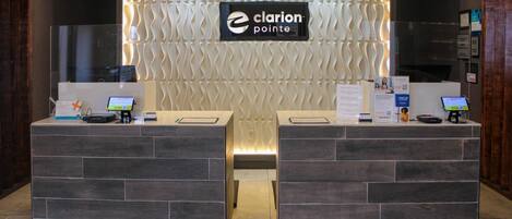 A reception desk with a modern design, featuring a logo and a nameplate.