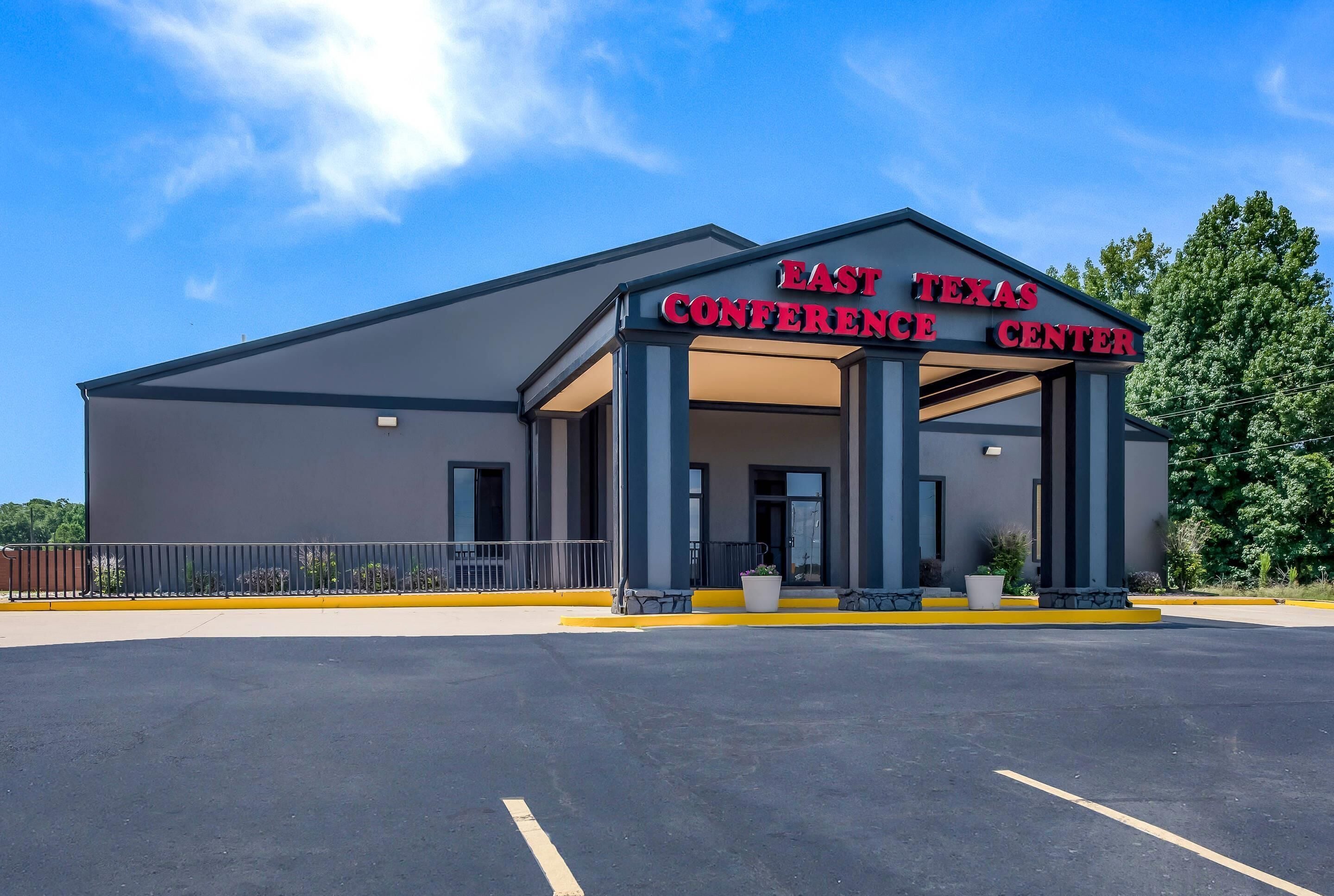 The East Texas Conference Center with a modern architectural design, featuring a large entrance and a parking lot.
