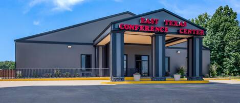 The East Texas Conference Center with a modern architectural design, featuring a large entrance and a parking lot.