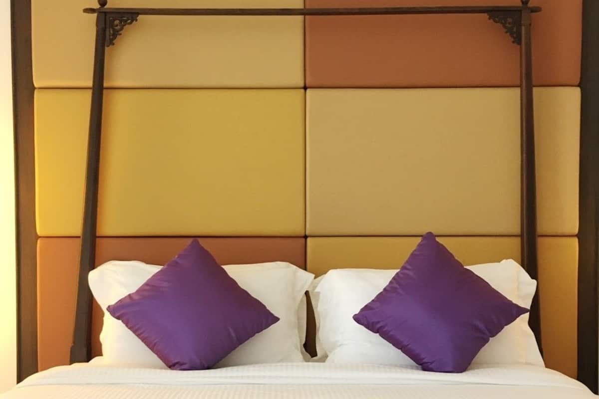 Een bed met hoofdbord met een geometrisch patroon en een metalen frame.