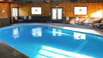 An indoor swimming pool with a wooden interior, a diving sign, and a bench area.
