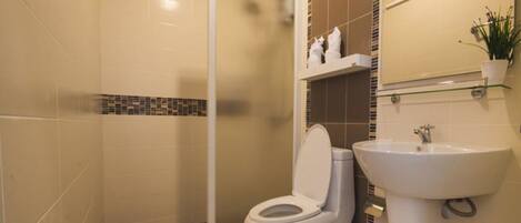 Un baño con ducha, inodoro y lavamanos.