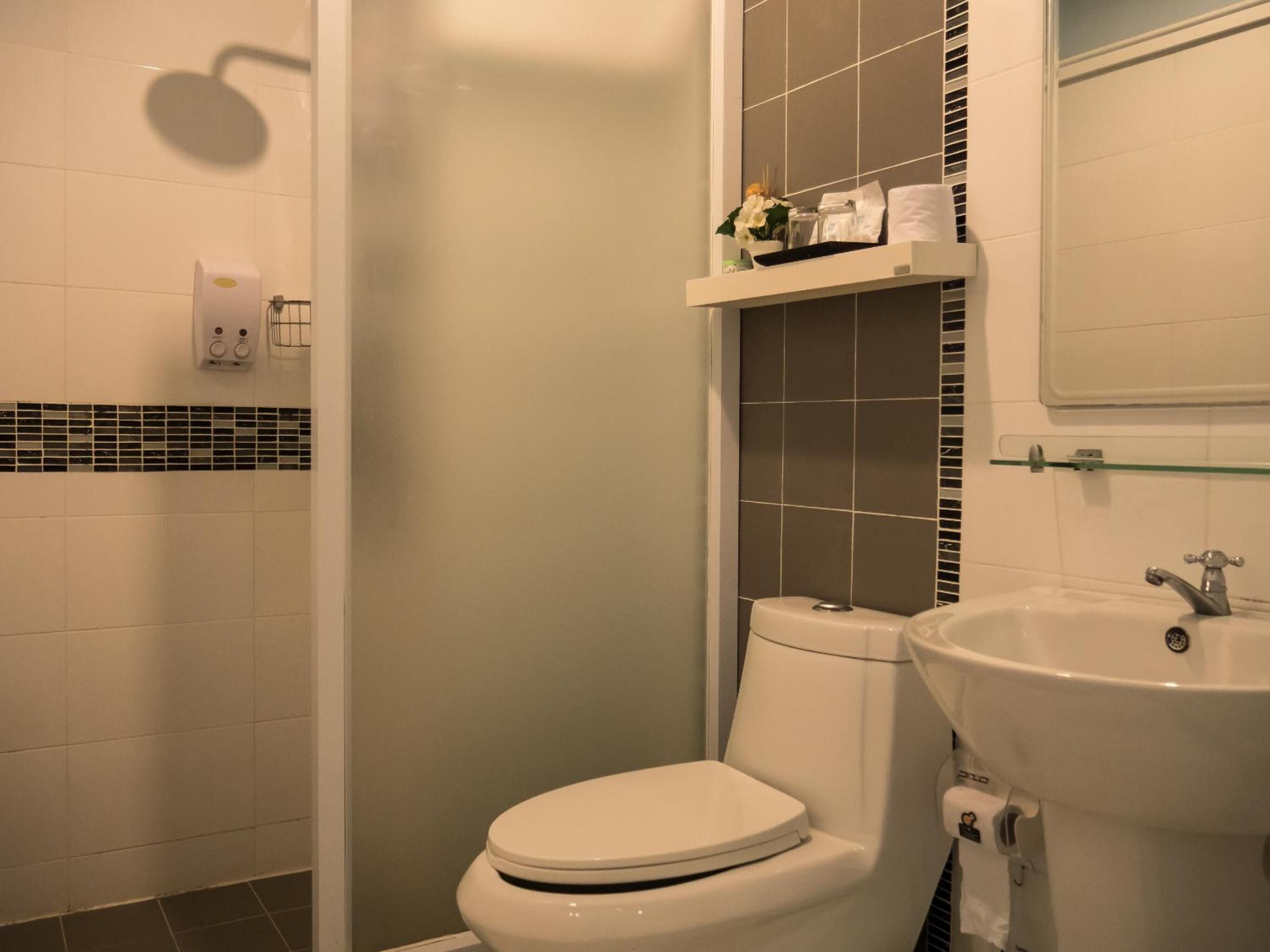 A bathroom with a toilet, a sink, and a shower.