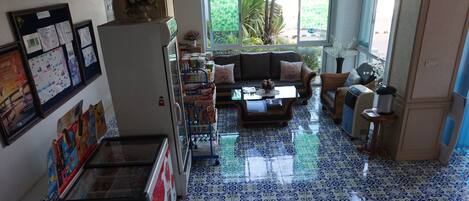 A living room with a patterned floor, a sofa, a coffee table, and a refrigerator.