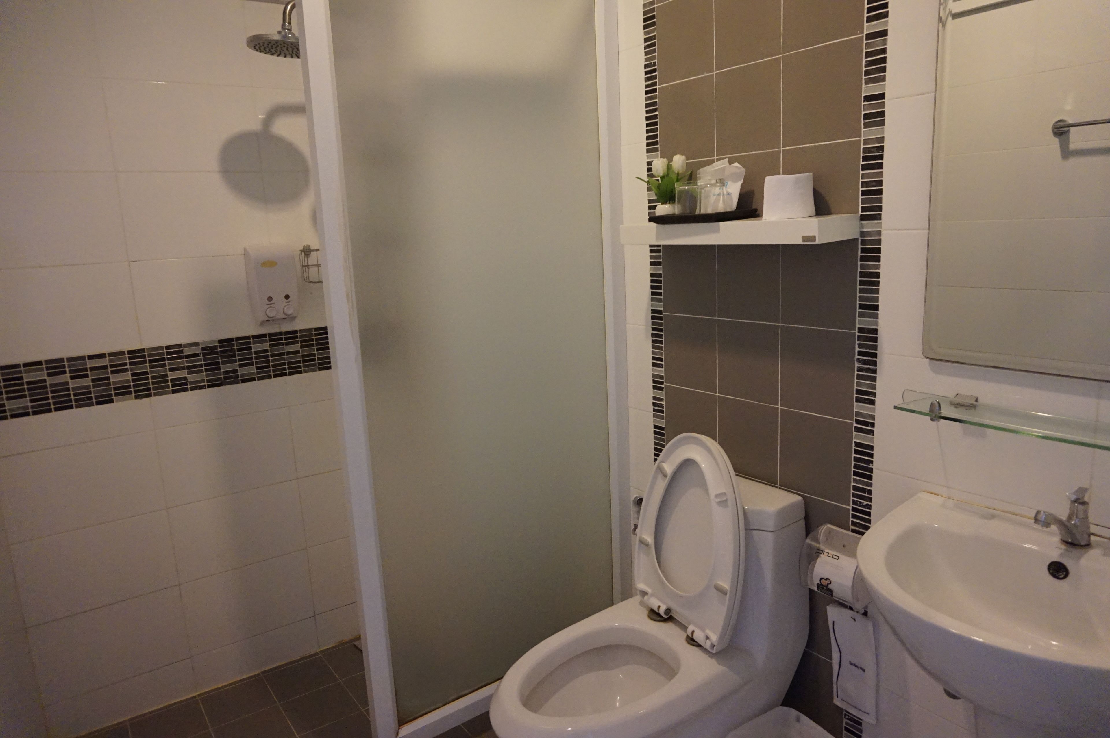 A bathroom with a toilet, sink, and shower.