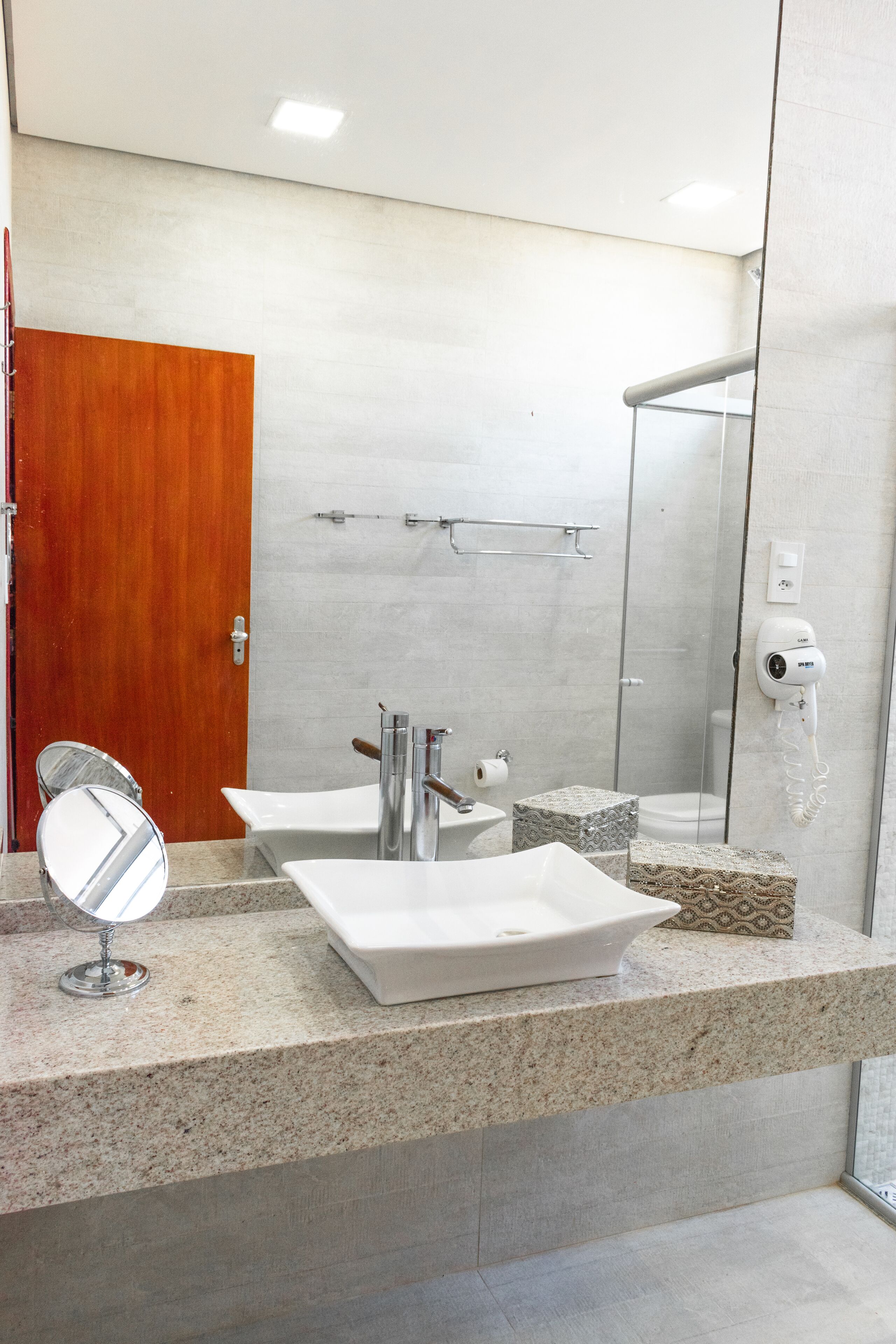 Un baño moderno con lavamanos doble, espejo, ducha y toallero.