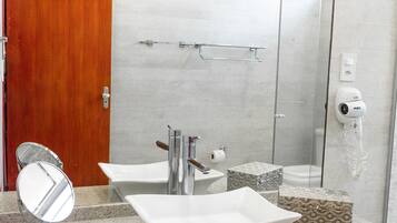 Un baño moderno con lavamanos doble, espejo, ducha y toallero.