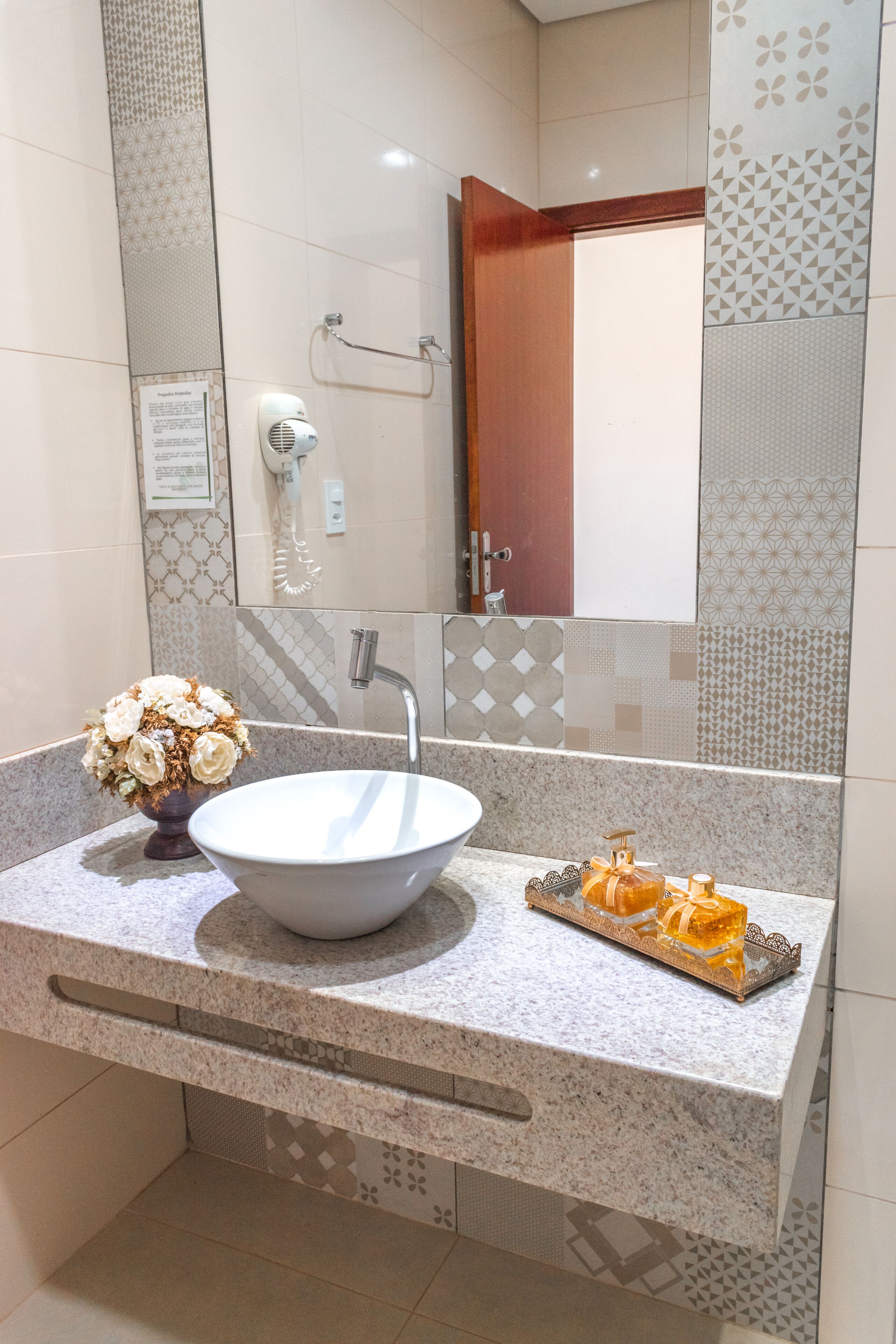 Un baño con un lavamanos grande, un perchero para toallas y un espejo.