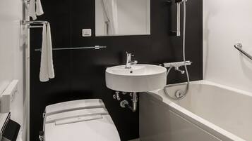 A modern bathroom with a toilet, sink, and bathtub.
