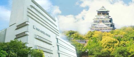 A modern hotel with a traditional Japanese castle in the background.