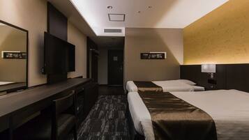 Une chambre d’hôtel avec un lit, un bureau, une télévision et un miroir.