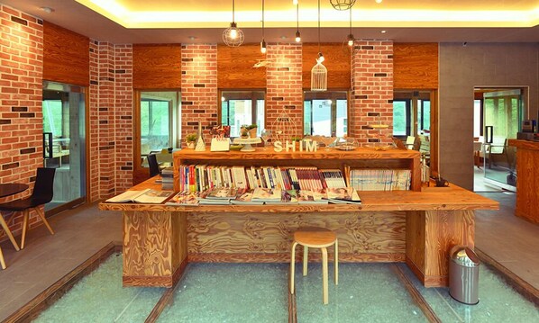 A cozy bar area with a wooden counter, bookshelves, and a stool.