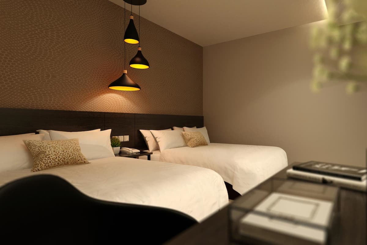 A modern hotel room with two beds, a desk, and a television.