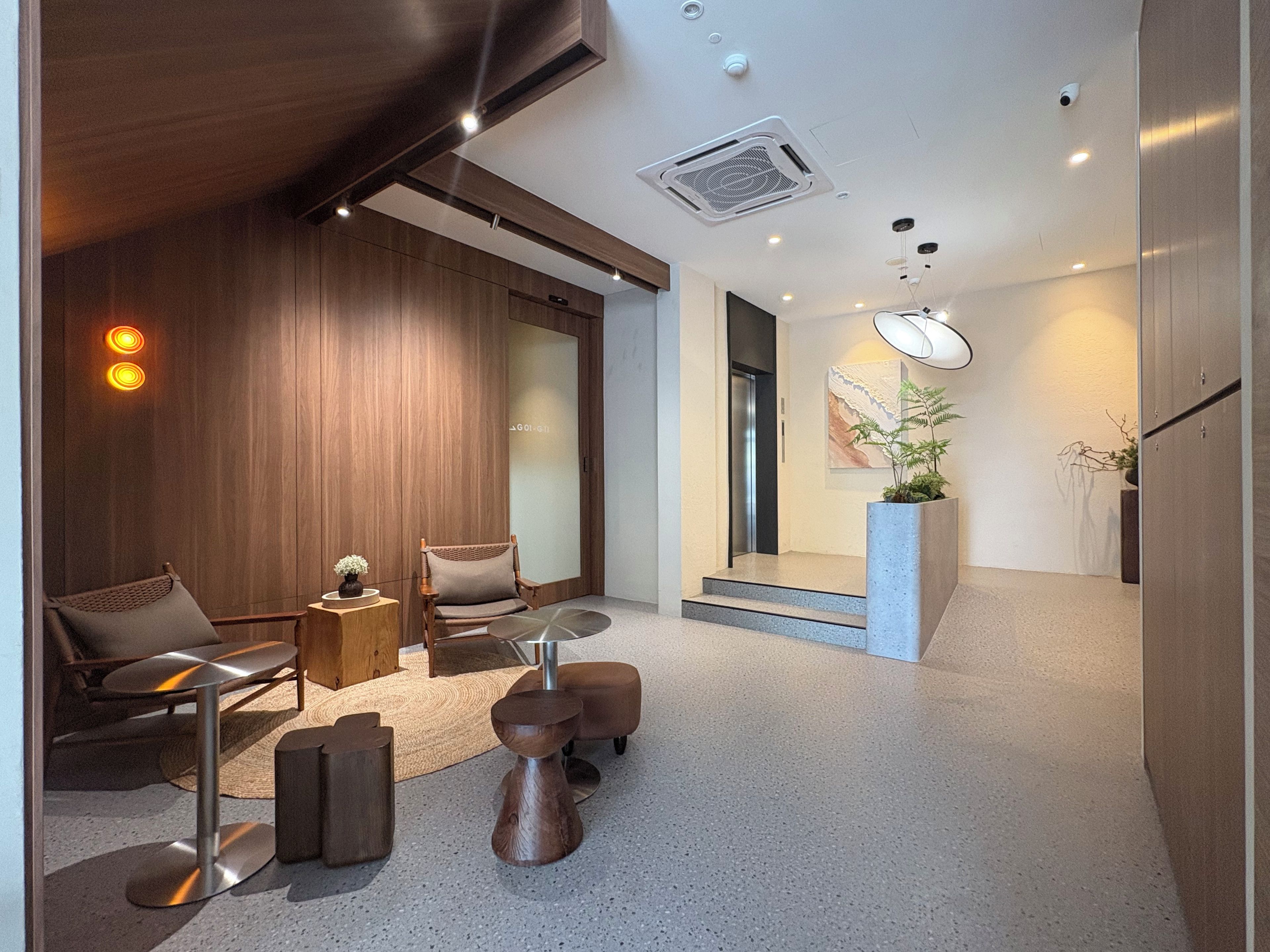 A modern interior with a seating area, a staircase, and a plant.