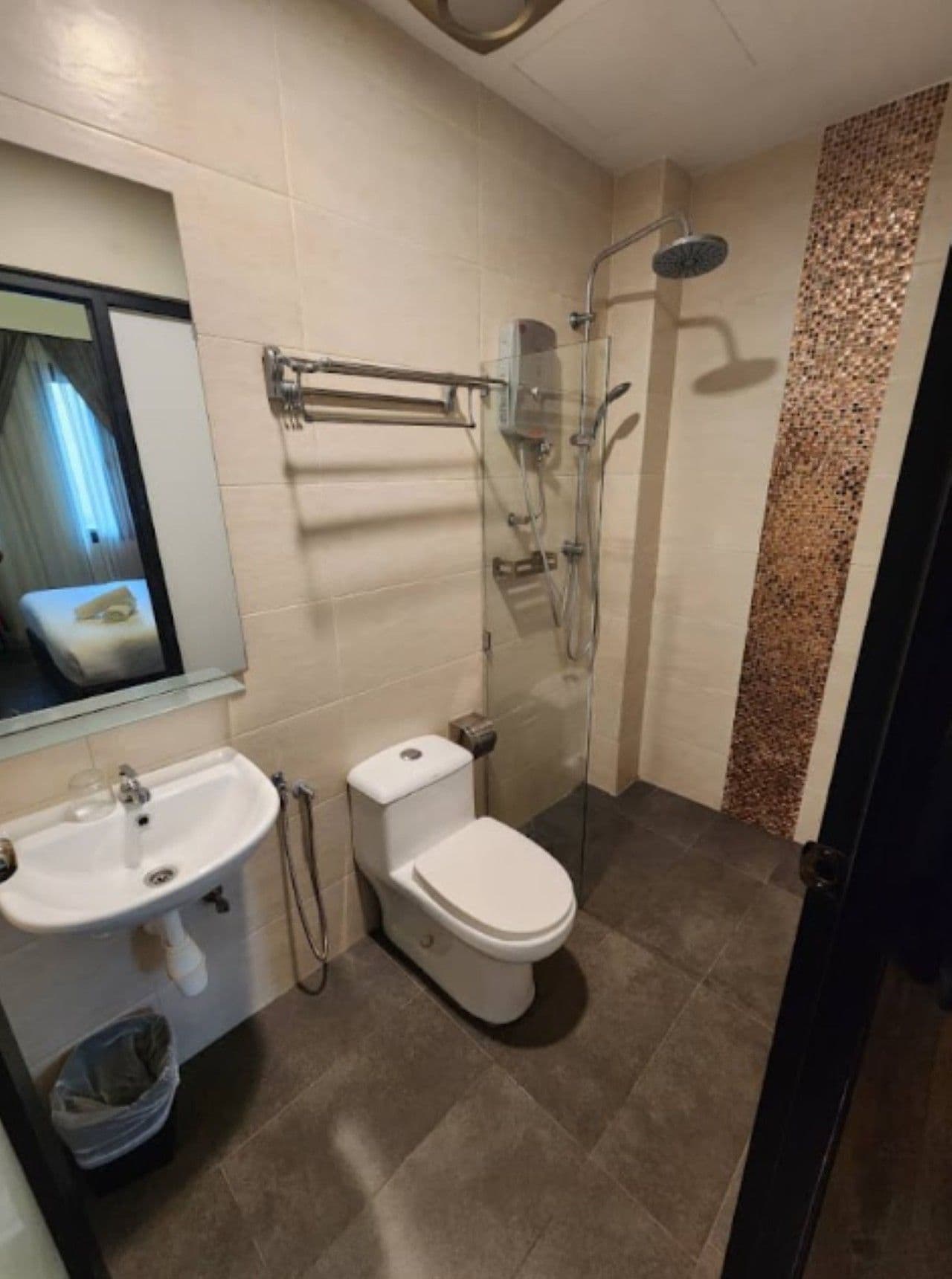 A bathroom with a toilet, sink, and shower.