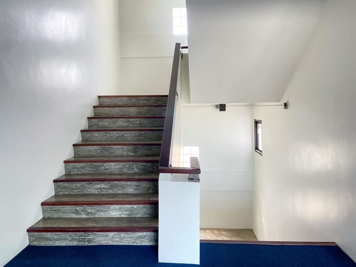 A staircase with wooden steps and a metal handrail.