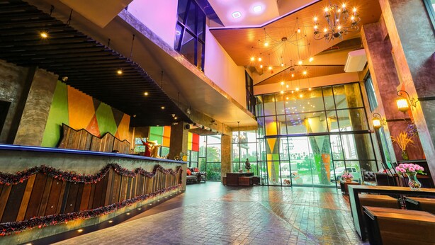 A spacious lobby with a staircase, large windows, and a chandelier. - PS Extra Hotel (Hat Yai)