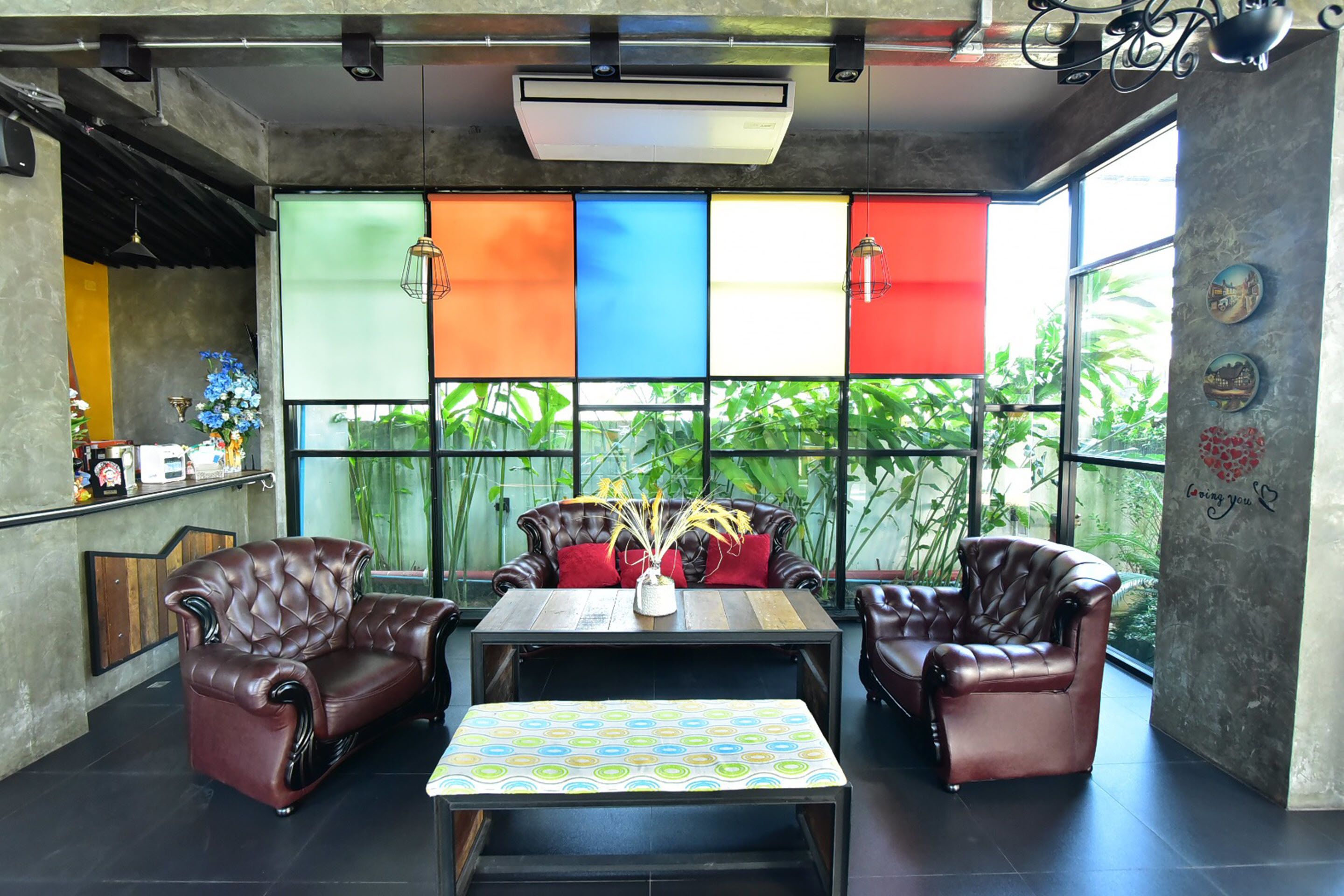 A modern lounge area with leather sofas, a wooden coffee table, and a colorful patterned tablecloth.