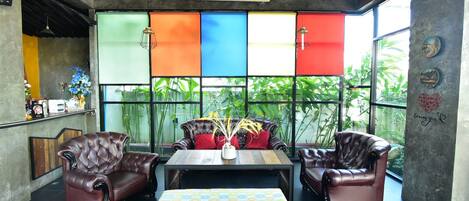 A modern lounge area with leather sofas, a wooden coffee table, and a colorful patterned tablecloth.