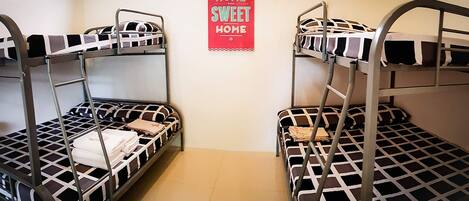 Dormitorio con literas y un cartel que dice 'Hogar Dulce Hogar'.