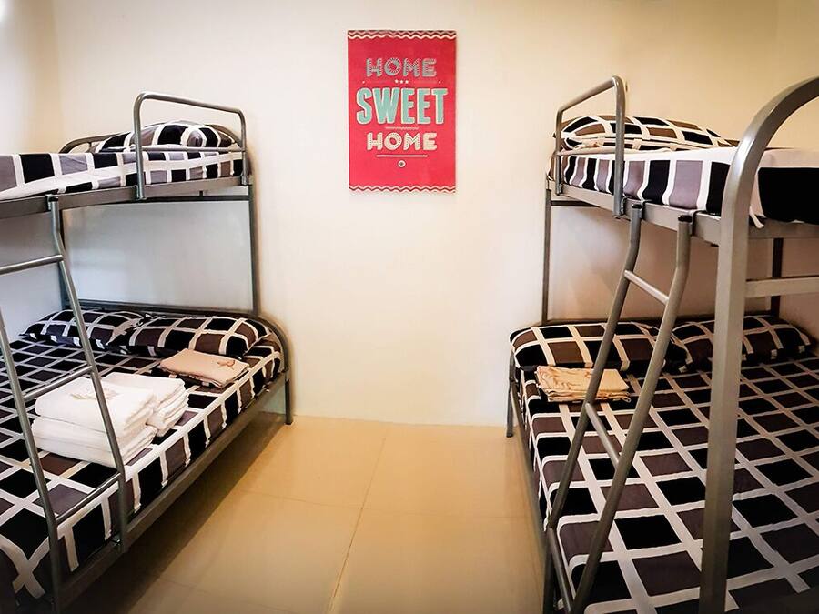 A bunk bed room with a 'Home Sweet Home' sign on the wall.