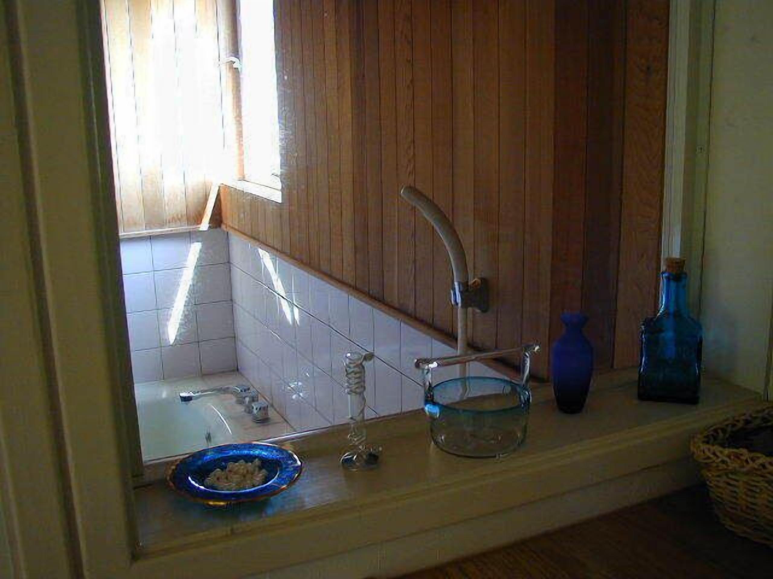 A bathroom with a wooden vanity, a sink, and a bathtub.