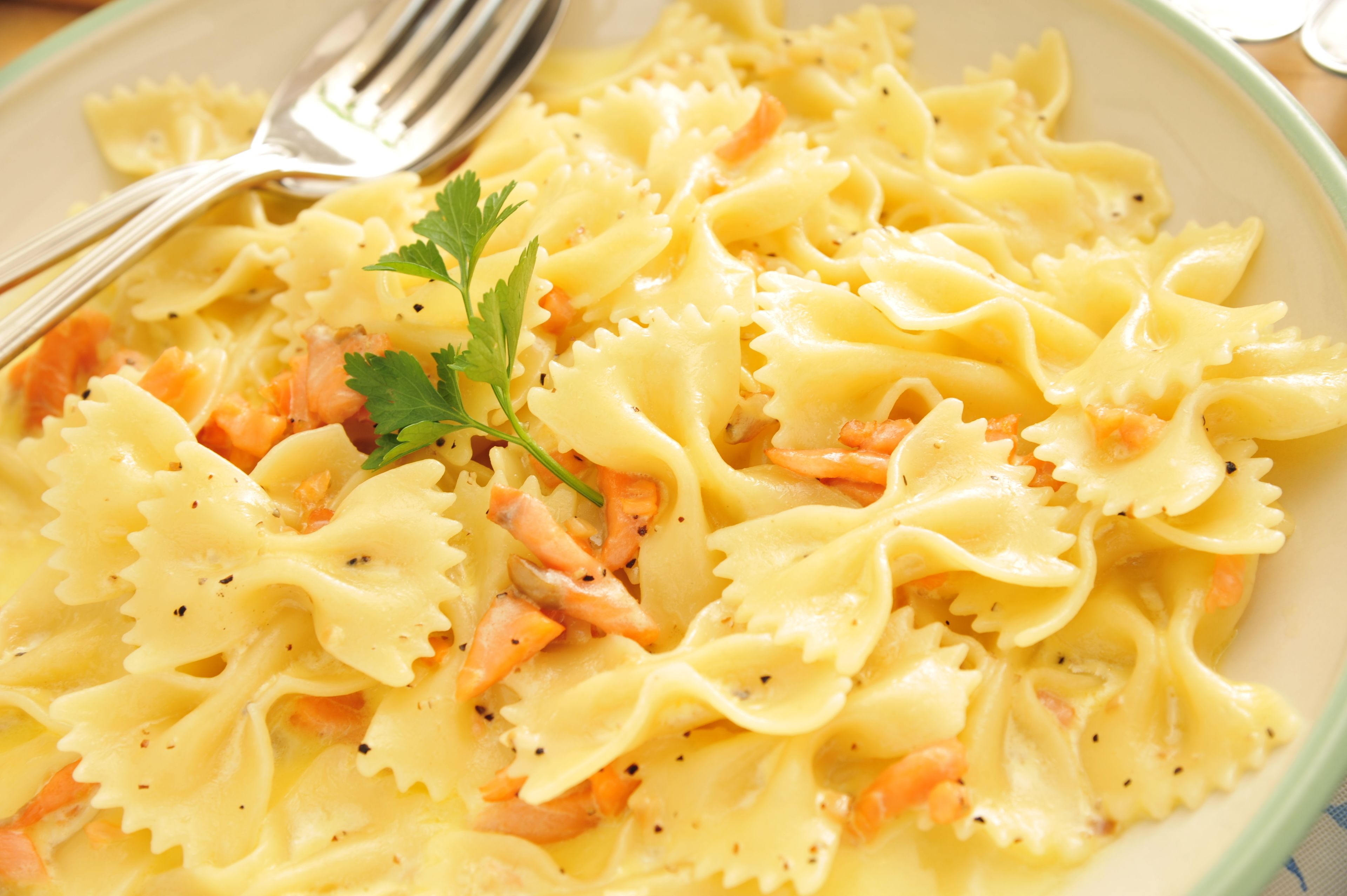 A plate of pasta with salmon and parsley garnish.