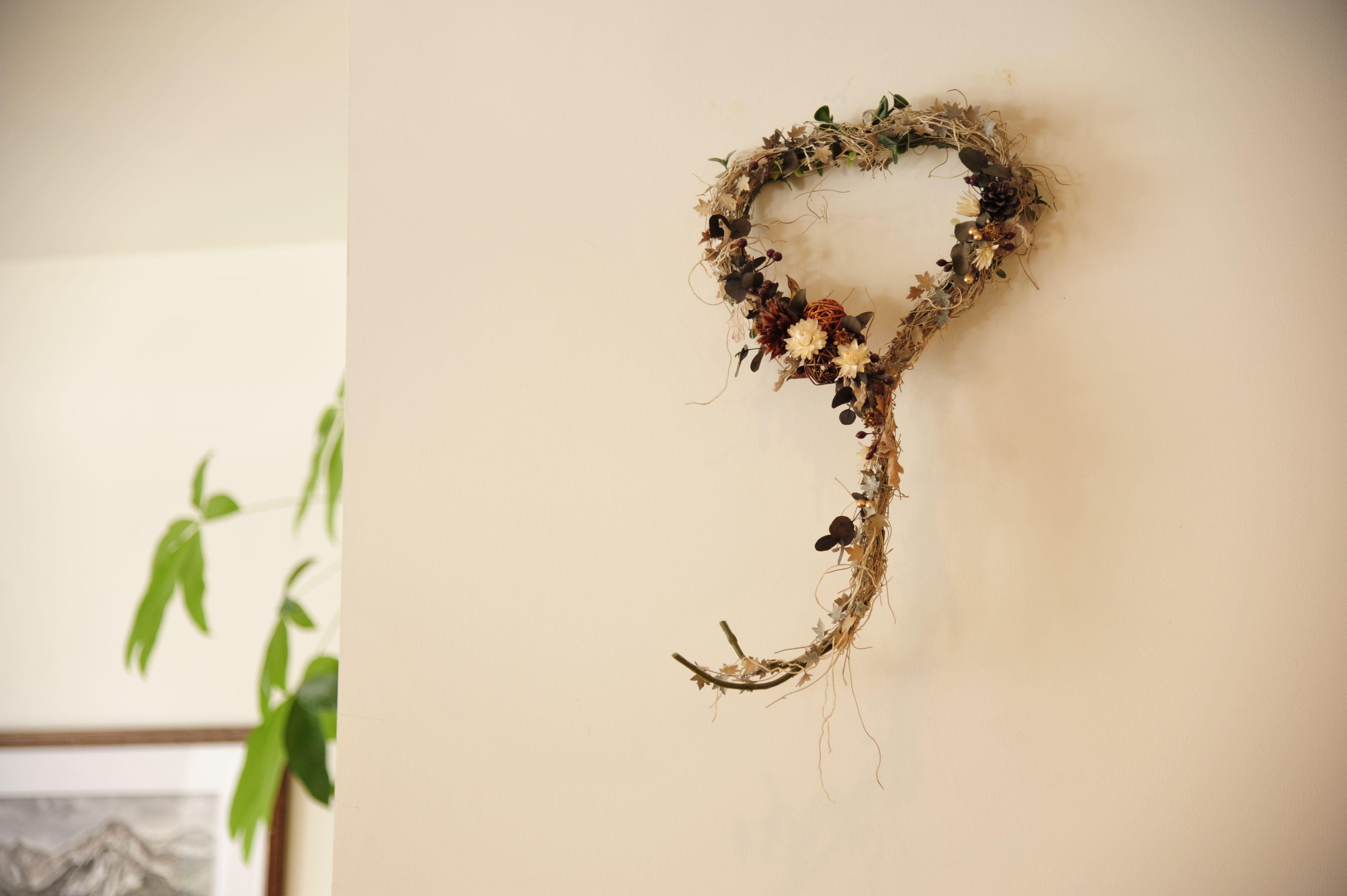 A wall-mounted decorative heart-shaped arrangement with natural elements.