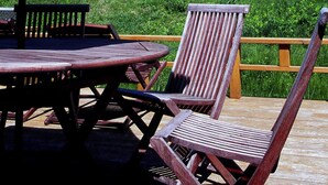 Une terrasse extérieure avec des meubles en bois, une table et un parasol.
