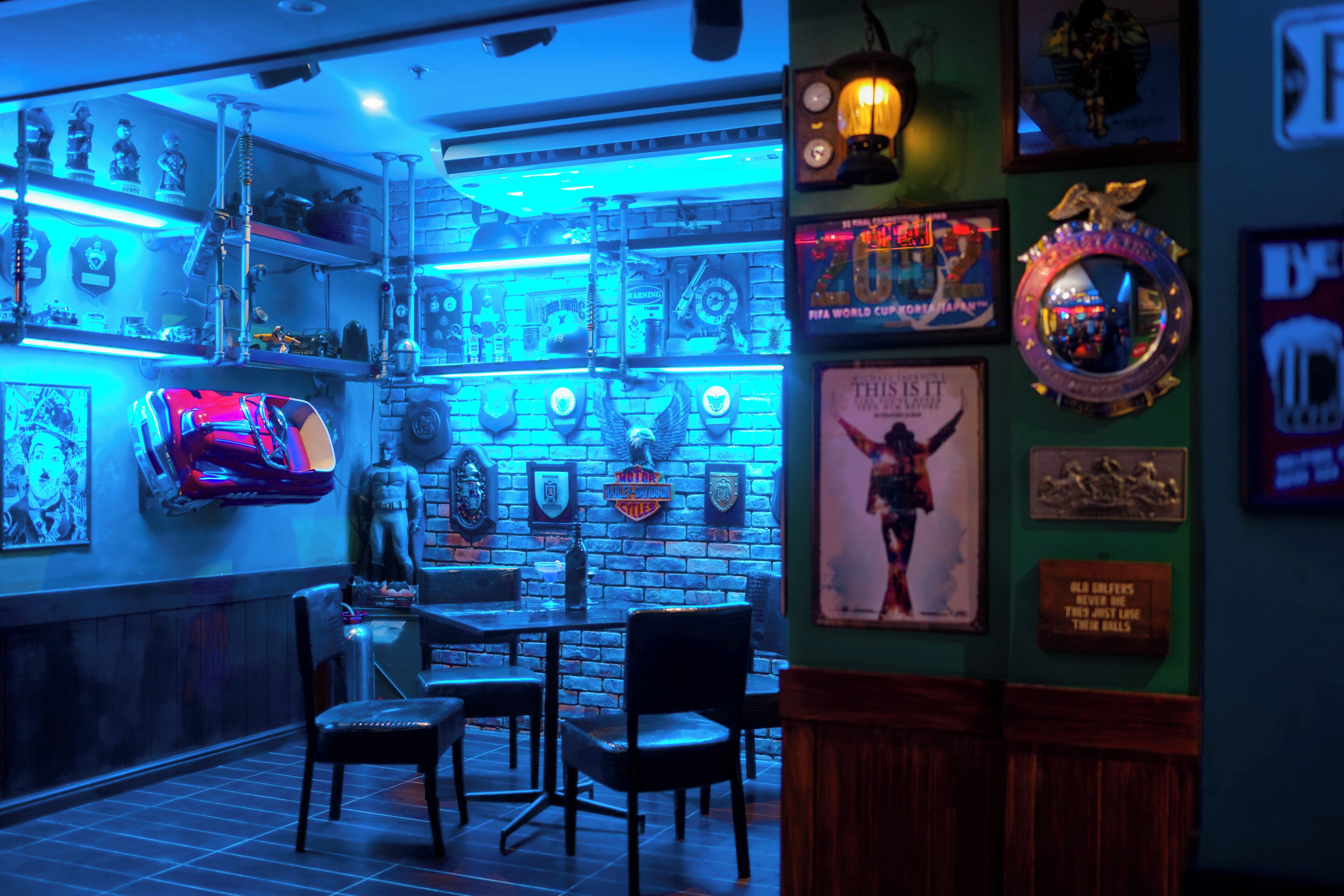 A bar area with a brick wall, shelves with memorabilia, and framed pictures.