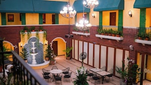 A courtyard with a fountain, outdoor seating, and potted plants.