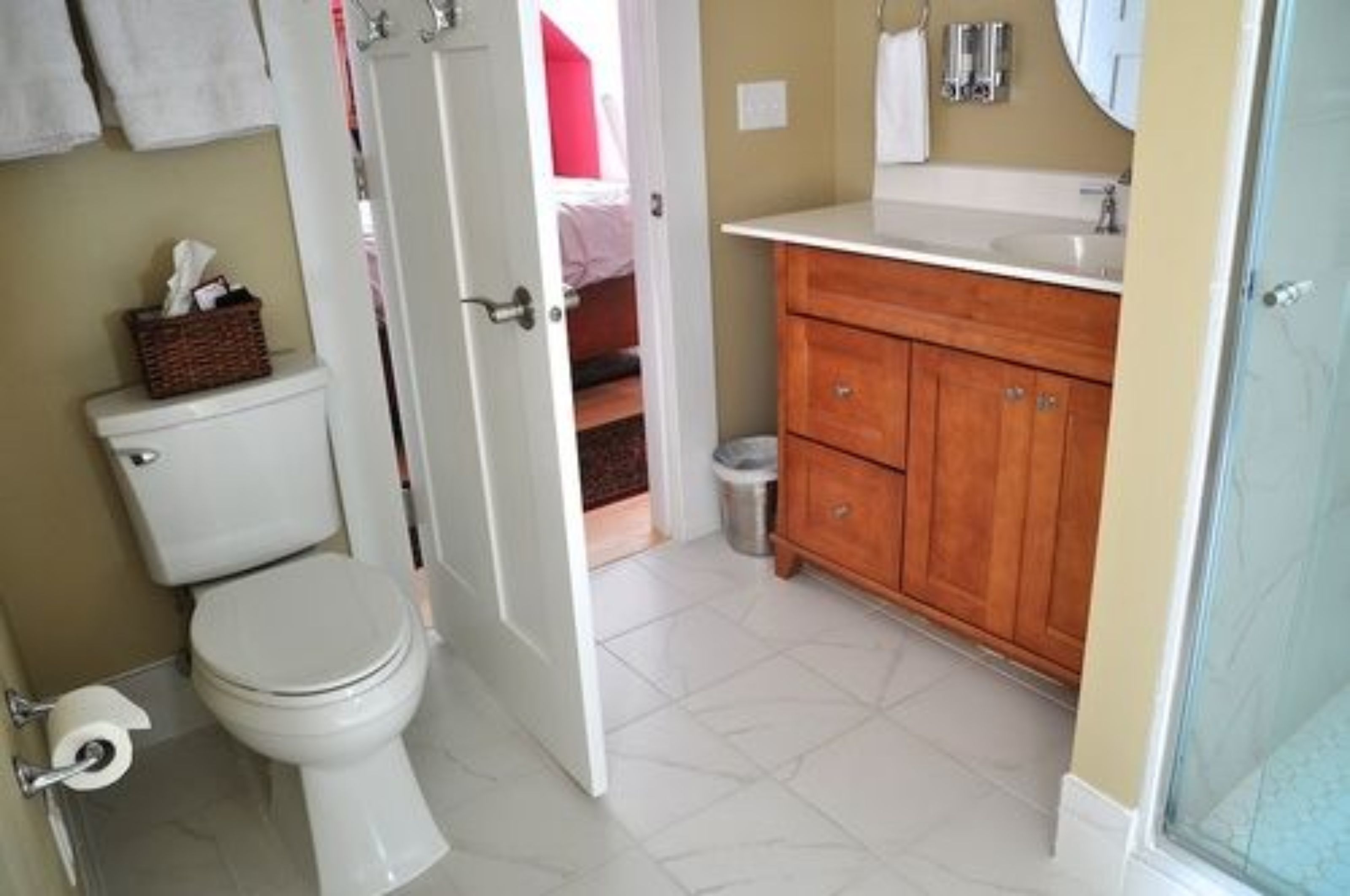 Une salle de bain comprenant des toilettes, un meuble-lavabo en bois et un espace douche.