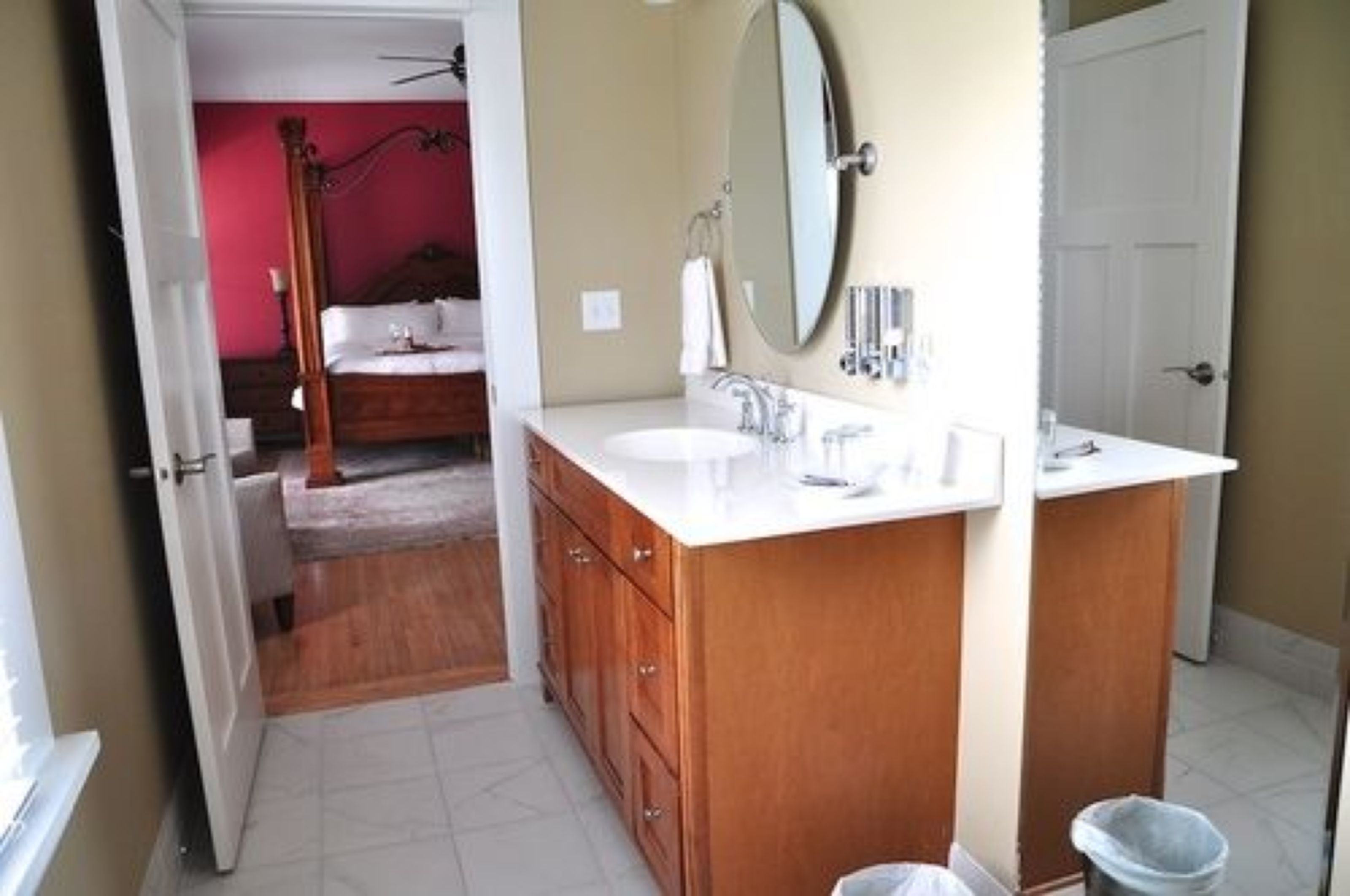 A bathroom with a wooden vanity, a large mirror, and a white sink.