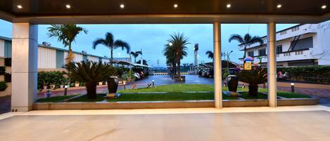 An indoor area with a view of a street and palm trees outside.