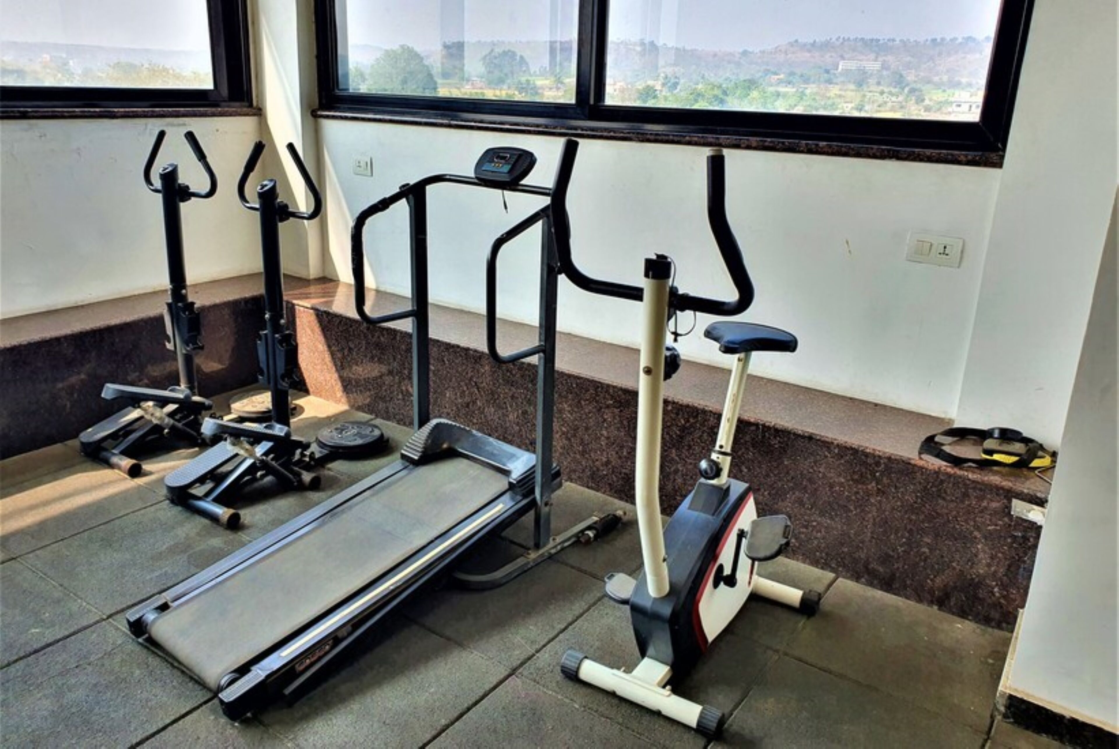 A gym with treadmills, elliptical machines, and weight benches.