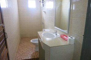 A small bathroom with a toilet, sink, and mirror.