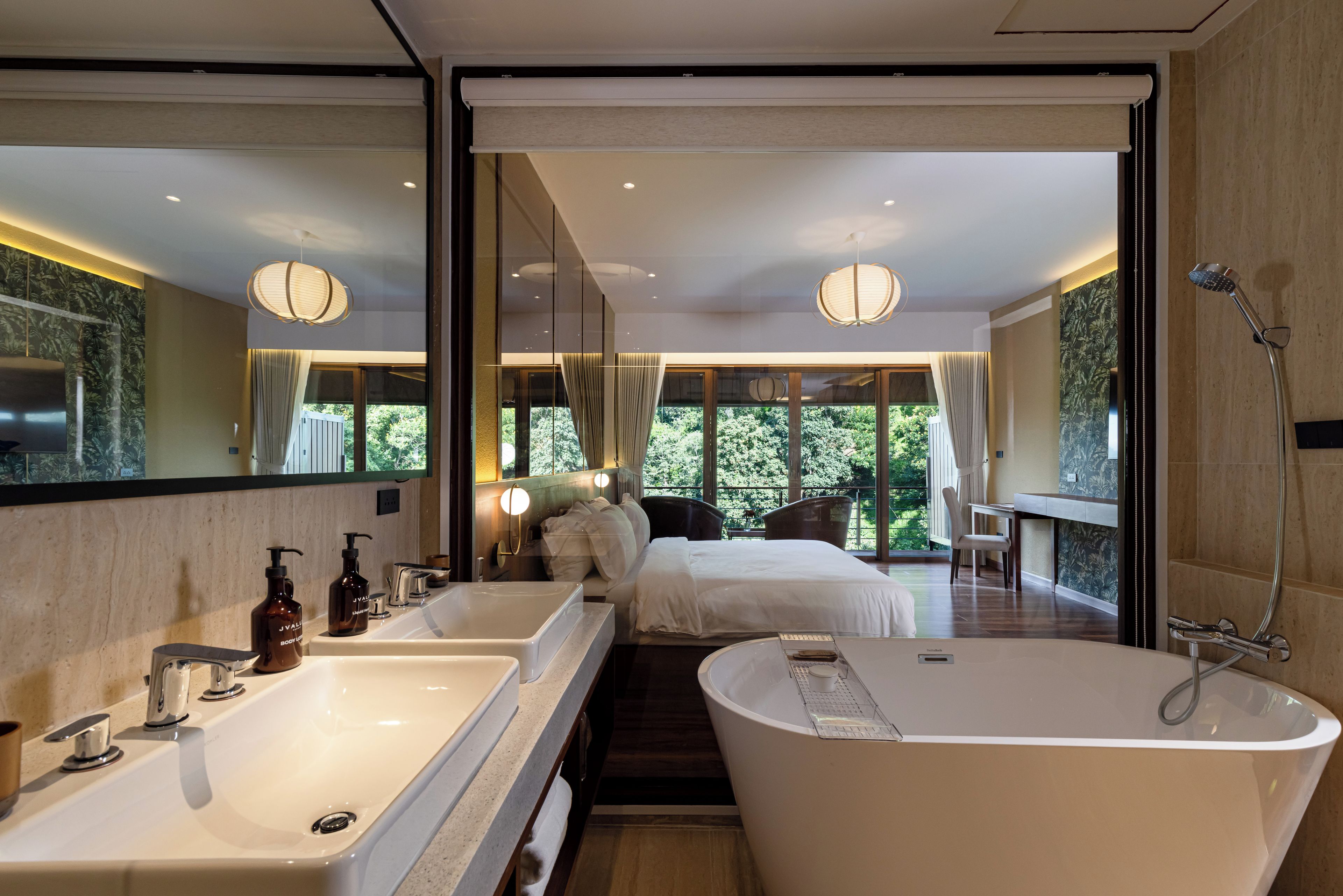A modern bathroom with a large bathtub, dual sinks, and a shower.