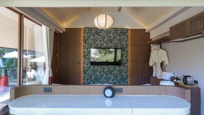 A modern bathroom with a large mirror, a built-in TV, and a towel rack.